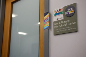 A Paul J. Burgett Intercultural Center sign for Assistant Dean for Diversity and BIC Director Dr. Jessica Guzman-Rea is covered with a rainbow Meliora sticker and a rainbow "Safe Space" sticker.