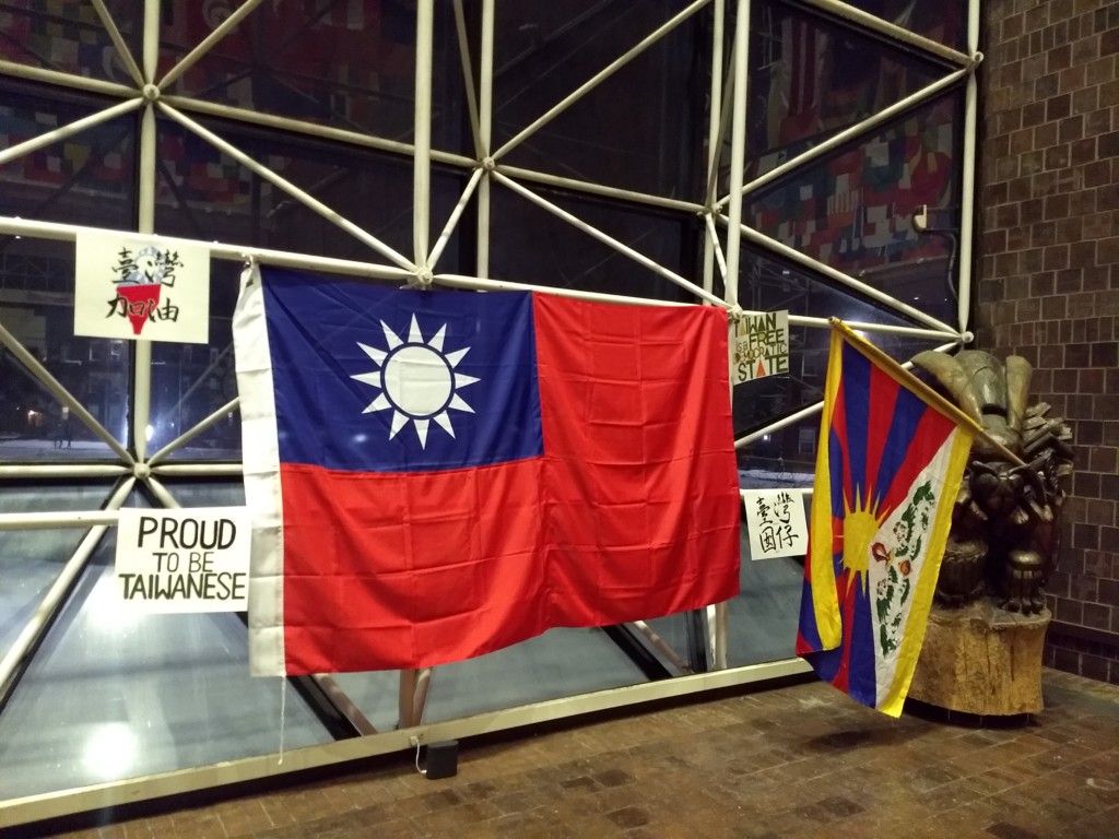 Students hang Taiwanese flag beneath flag display